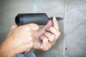 Woman working at home with drill and screwdriver