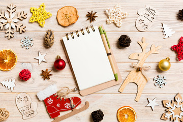 Top view of notebook on wooden background made of Christmas decorations. New Year concept