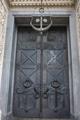 A heavy metal door richly decorated with ornaments in the historical part of Kronstadt, Russia