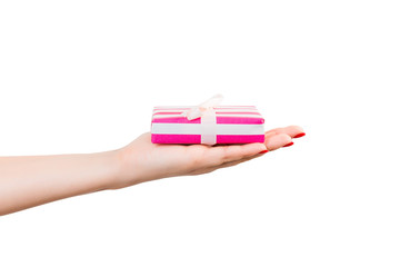 Woman hands give wrapped Christmas or other holiday handmade present in pink paper with white ribbon. Isolated on white background, top view. thanksgiving Gift box concept