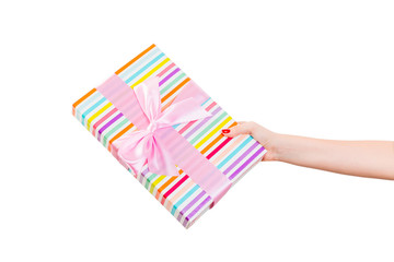 Fototapeta na wymiar Woman hands give wrapped Christmas or other holiday handmade present in colored paper with pink ribbon. Isolated on white background, top view. thanksgiving Gift box concept