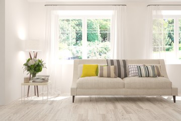 Obraz na płótnie Canvas Stylish room in white color with sofa and summer landscape in window. Scandinavian interior design. 3D illustration