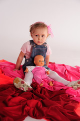 girl in the studio sitting on the floor with a doll