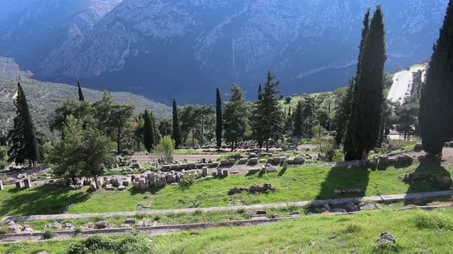 Top view horizon of the Delphi sanctuary ruins with lush greenery and beautiful blue mountain landscape background in Phocis, Greece.