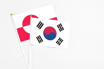 South Korea and Greenland stick flags on white background. High quality fabric, miniature national flag. Peaceful global concept.White floor for copy space.