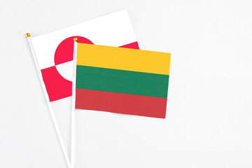 Lithuania and Greenland stick flags on white background. High quality fabric, miniature national flag. Peaceful global concept.White floor for copy space.