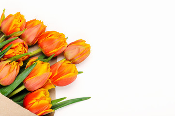 A bouquet of tulips in craft pack on a white background. Spring floral background. Copy space, Top view, flat lay.