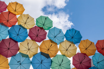 Fototapeta na wymiar Colourful sun umbrellas against the blue sky. Street decoration. Copy space.