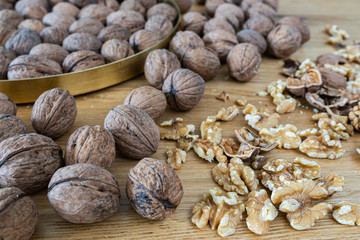 Walnuts on a natural oak wooden background. A natural perspective composition in brown and gold  colors.