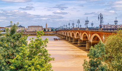 Panoramic view of Bordeaux with Saint Michel cathedral and Pont de Pierre, old stone bridge over the river Garonne.
