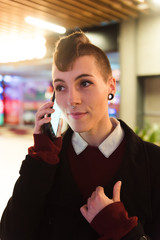 Female businesswoman with curly hair and modern style answers a call in a mall.