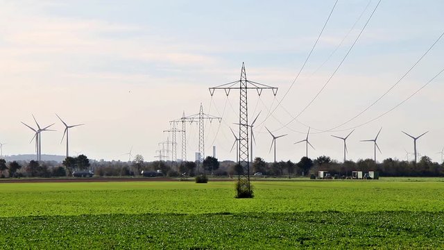 Strommasten und Windkraft Anlagen in der gr&uuml;nen Landschaft