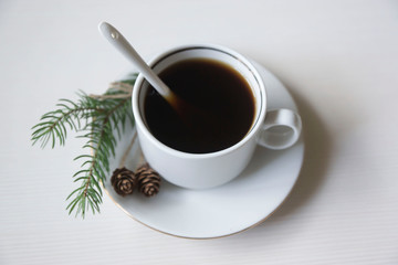 A cup of coffee with a sprig of spruce for the New Year mood.