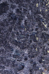 Black velvet fabric through drops of water on the glass. Bizarre patterns created by the refraction of light.