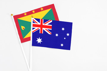 Fototapeta premium Australia and Grenada stick flags on white background. High quality fabric, miniature national flag. Peaceful global concept.White floor for copy space.