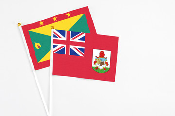 Bermuda and Grenada stick flags on white background. High quality fabric, miniature national flag. Peaceful global concept.White floor for copy space.