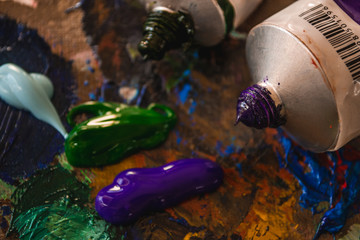 A palette with paints, oil and acrylic. Bright colors, palette knife and brush.
