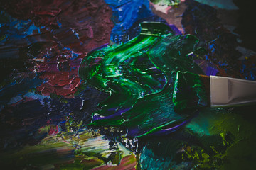 A palette with paints, oil and acrylic. Bright colors, palette knife and brush.