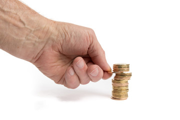 a hand placing or removing another coin onto a rough stack of unidentified gold coins isolated on...