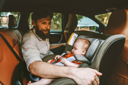 Father and baby in car child sitting in safety seat happy family lifestyle road trip vacations rental auto rear-facing transportation