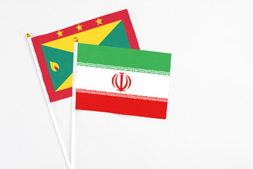 Iran and Grenada stick flags on white background. High quality fabric, miniature national flag. Peaceful global concept.White floor for copy space.