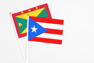 Puerto Rico and Grenada stick flags on white background. High quality fabric, miniature national flag. Peaceful global concept.White floor for copy space.