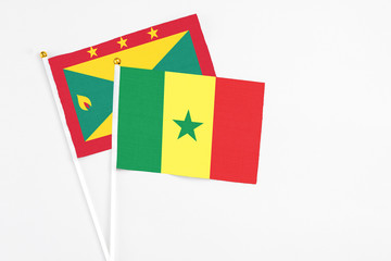 Senegal and Grenada stick flags on white background. High quality fabric, miniature national flag. Peaceful global concept.White floor for copy space.