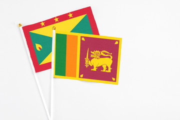 Sri Lanka and Grenada stick flags on white background. High quality fabric, miniature national flag. Peaceful global concept.White floor for copy space.