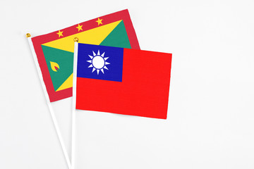 Taiwan and Grenada stick flags on white background. High quality fabric, miniature national flag. Peaceful global concept.White floor for copy space.