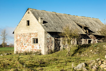 Fototapeta na wymiar Late autumn. Yard of an old abandoned farm. Ruined barns and a cellar. Former dairy industry. Podlasie, Poland.