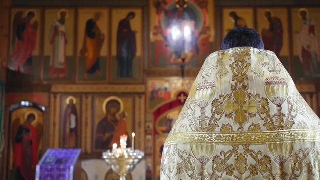 The holy father reads a prayer in the church before the ritual of baptism. Secret rite of baptism in the orthodox church. Medium shot.