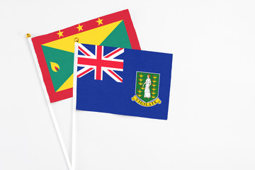 Fototapeta premium British Virgin Islands and Grenada stick flags on white background. High quality fabric, miniature national flag. Peaceful global concept.White floor for copy space.