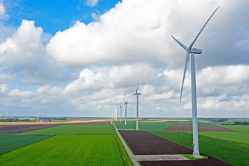 Aerial from a dutch landscape with windturbines, meadows and beautiful skies