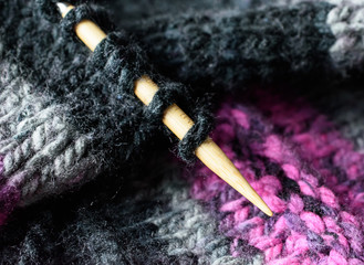 Closeup of Knitting Needle and Stitch Loops in Black Pink and Grey Variegated Wool