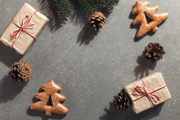 Christmas gingerbread cookies in the shape of a Christmas tree and craft gifts on a stone background, copy space.