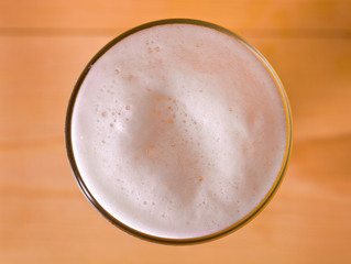 Glass of beer on a wooden background. Top view.