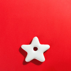 Christmas gingerbread in the shape of a star on a red background, copy space.