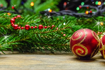 Two red Christmas balls on the background of Christmas tree branches close-up. Beautiful Christmas and New year background