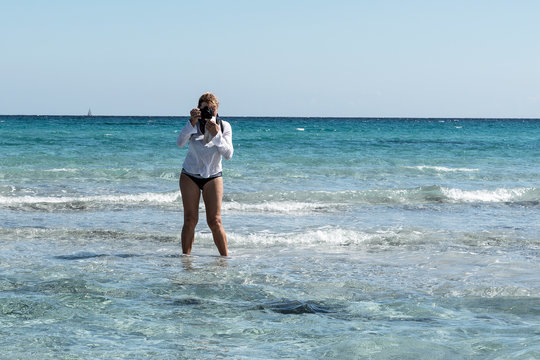 Photographer by the blue sea.