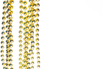 Golden christmas beads on marble background. Christmas frame. Line of golden beads garland on a white background. Top view. Copy space