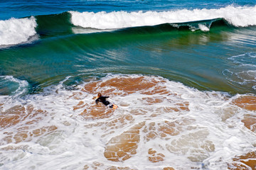 Aerial from a young surfer ready to surf at the atlantic ocean