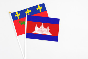 Cambodia and Guadeloupe stick flags on white background. High quality fabric, miniature national...