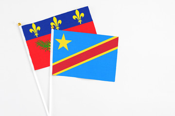 Congo and Guadeloupe stick flags on white background. High quality fabric, miniature national flag. Peaceful global concept.White floor for copy space.