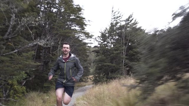 Male runner cross running on trail New Zealand