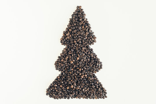 Christmas tree made from freshly roasted coffee beans on white table. Winter concept. Creative. Minimalism
