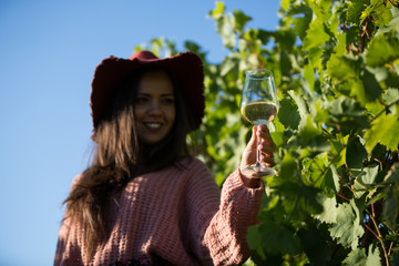 Smiling young woman looking down on her glass of wine