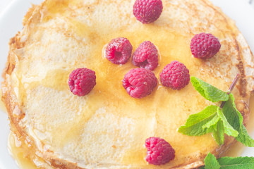 Stack of crepes with raspberries
