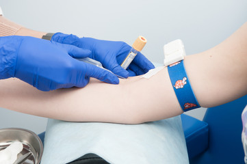 The doctor takes blood from a vein