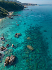 Aerial view of Tropea beach, crystal clear water and rocks that appear on the beach. Calabria, Italy. Swimmers, bathers floating on the water. Coastline of Calabria