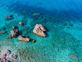 Aerial view of Tropea beach, crystal clear water and rocks that appear on the beach. Calabria, Italy. Swimmers, bathers floating on the water. Coastline of Calabria